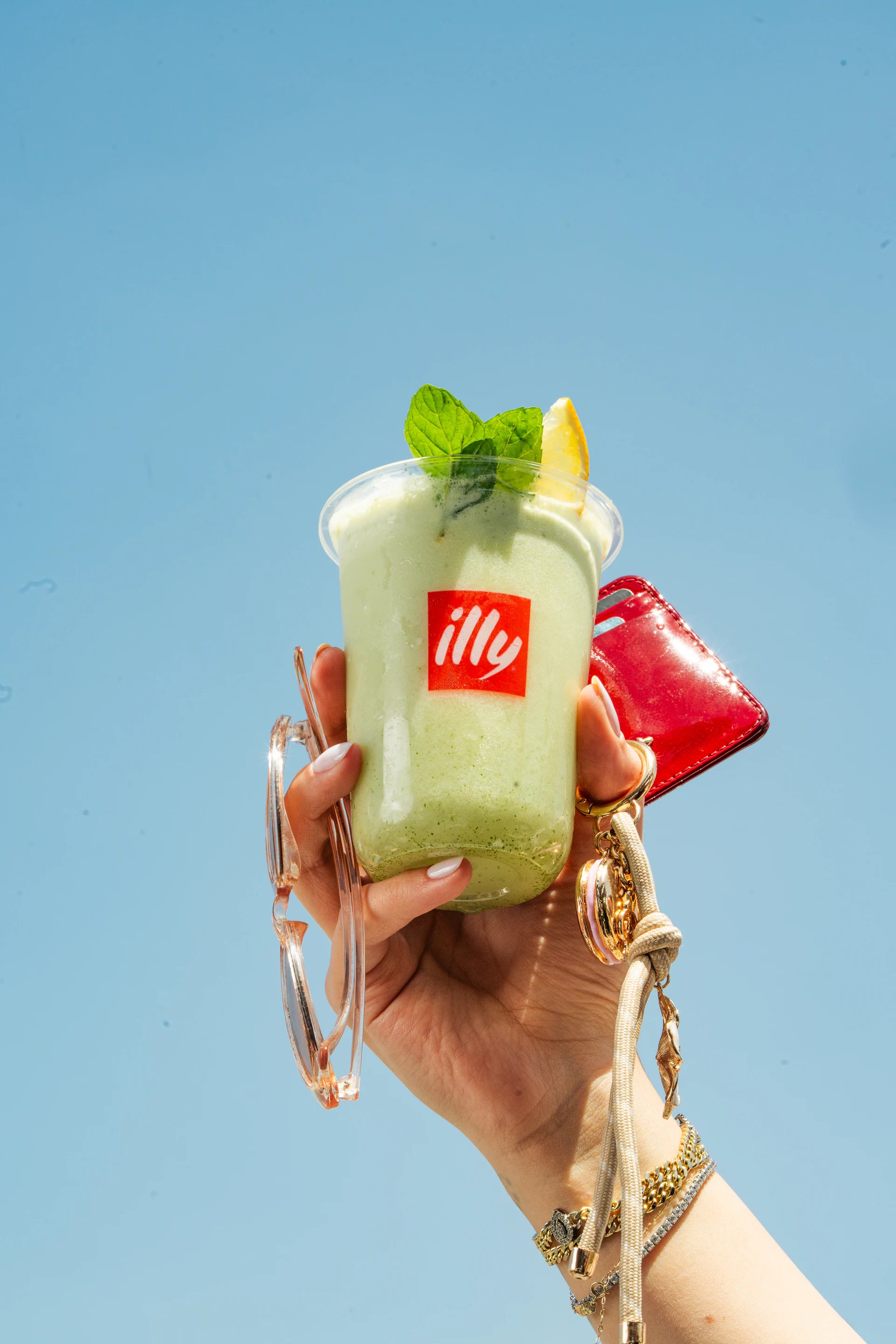 Close-up of a green illy drink against a clear blue sky