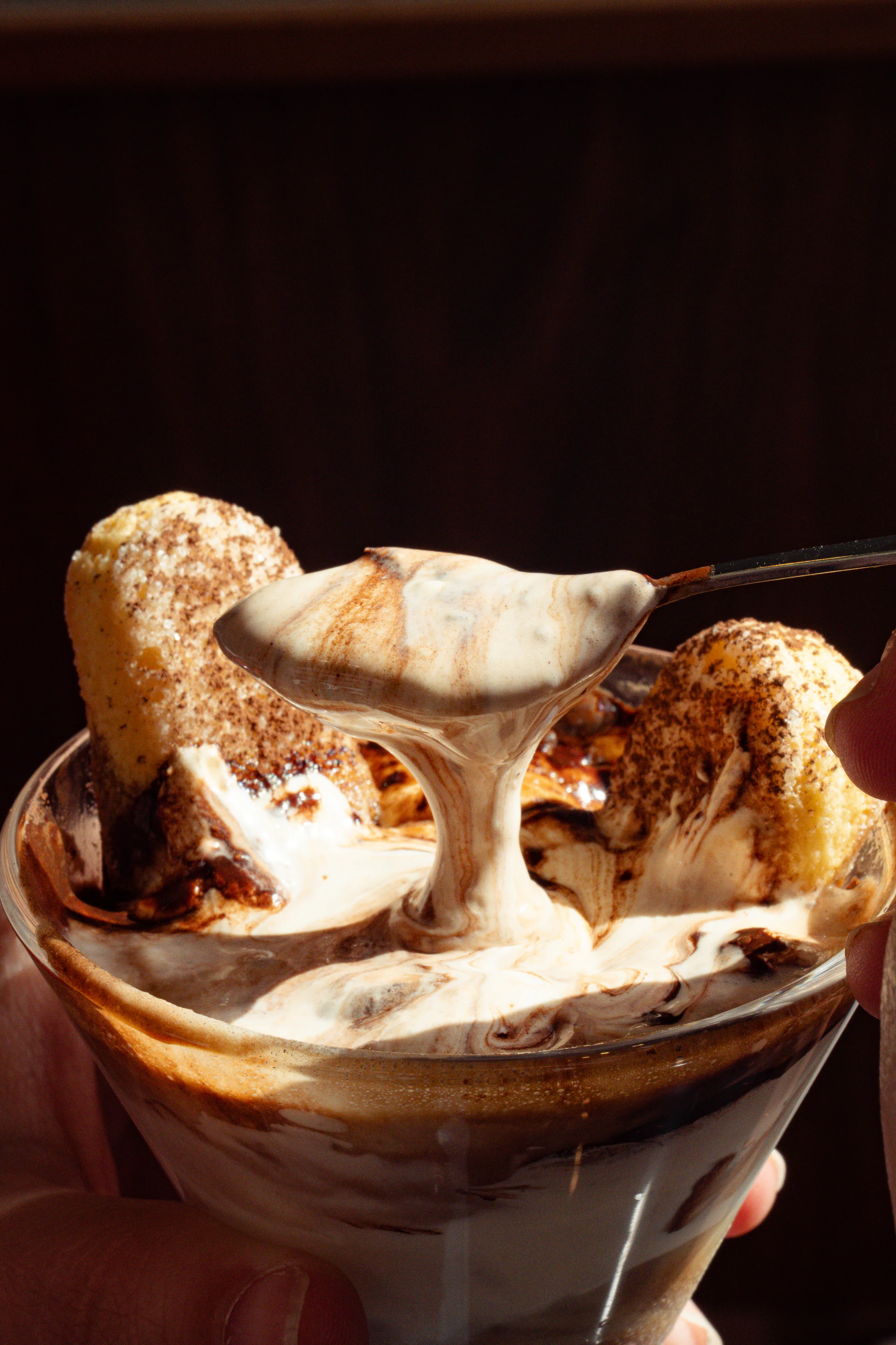Spoon lifting a creamy bite from an illymisu dessert glass