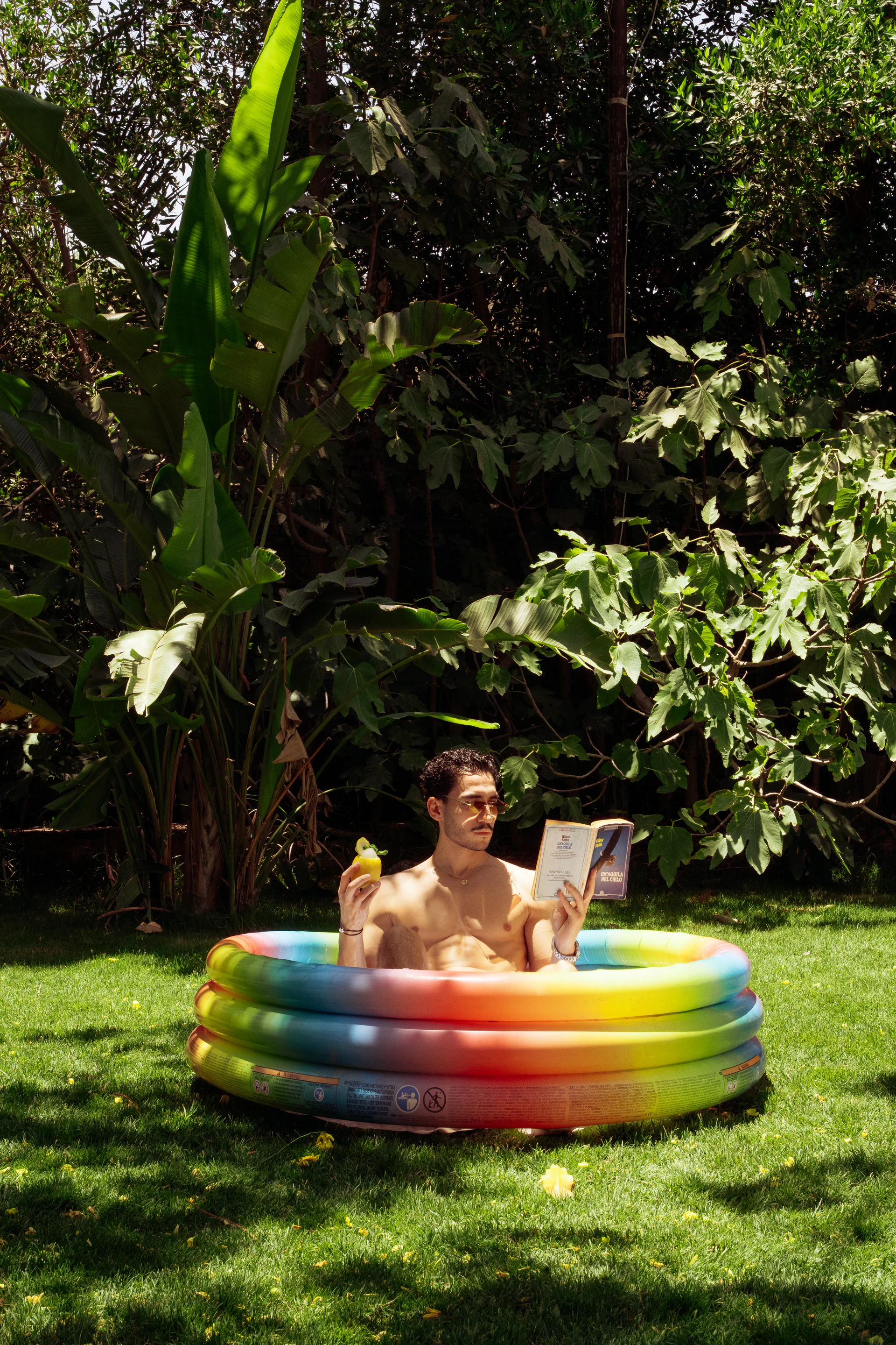Man reading with an illy drink in a colorful garden pool