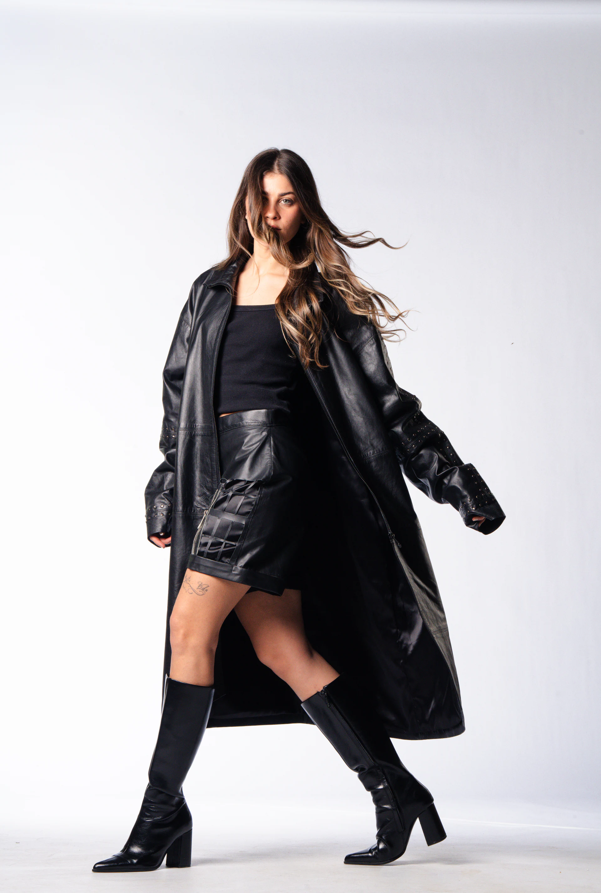 Leopelle editorial model walking in a black leather coat