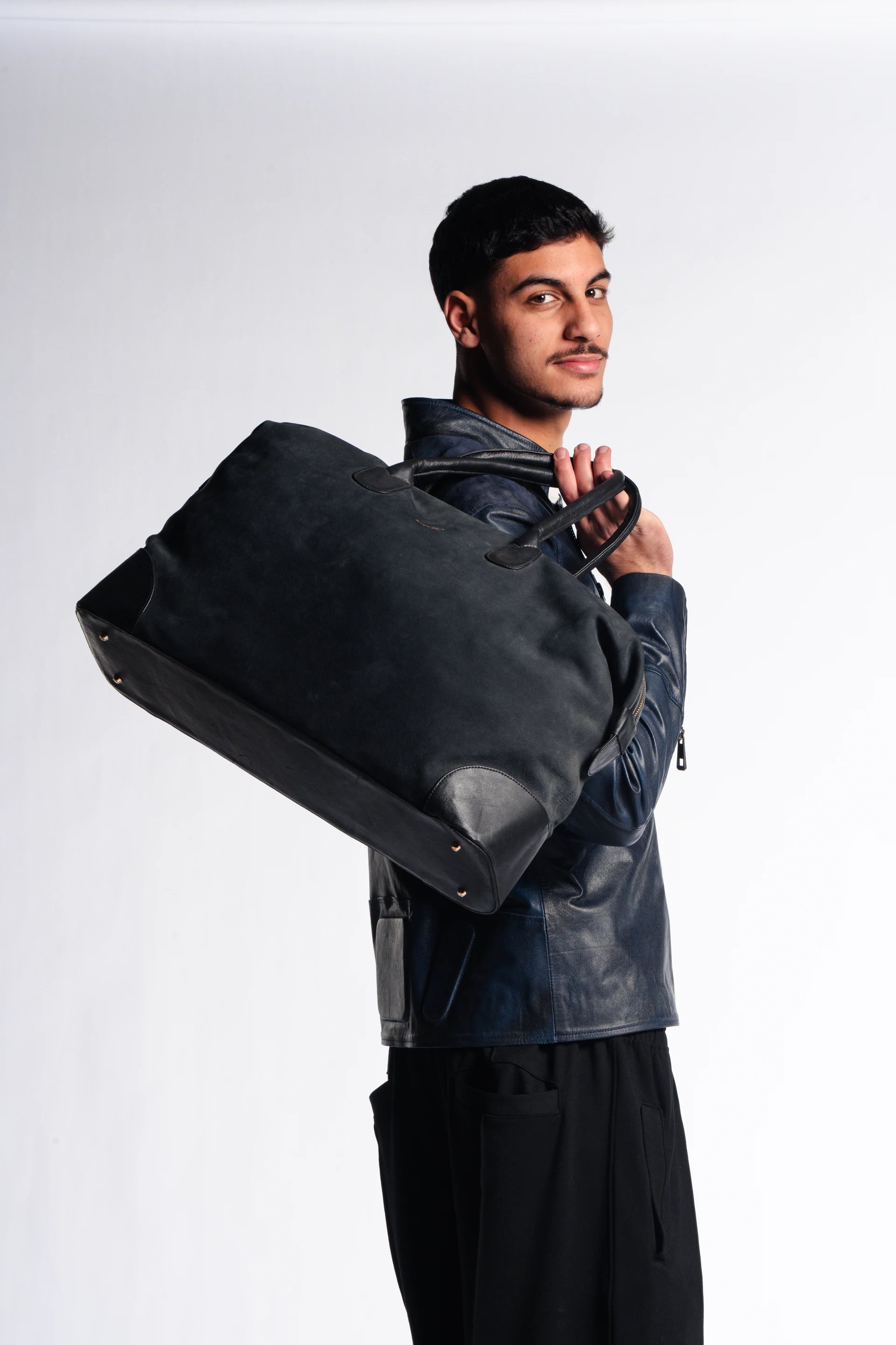 Leopelle model carrying an oversized black leather bag