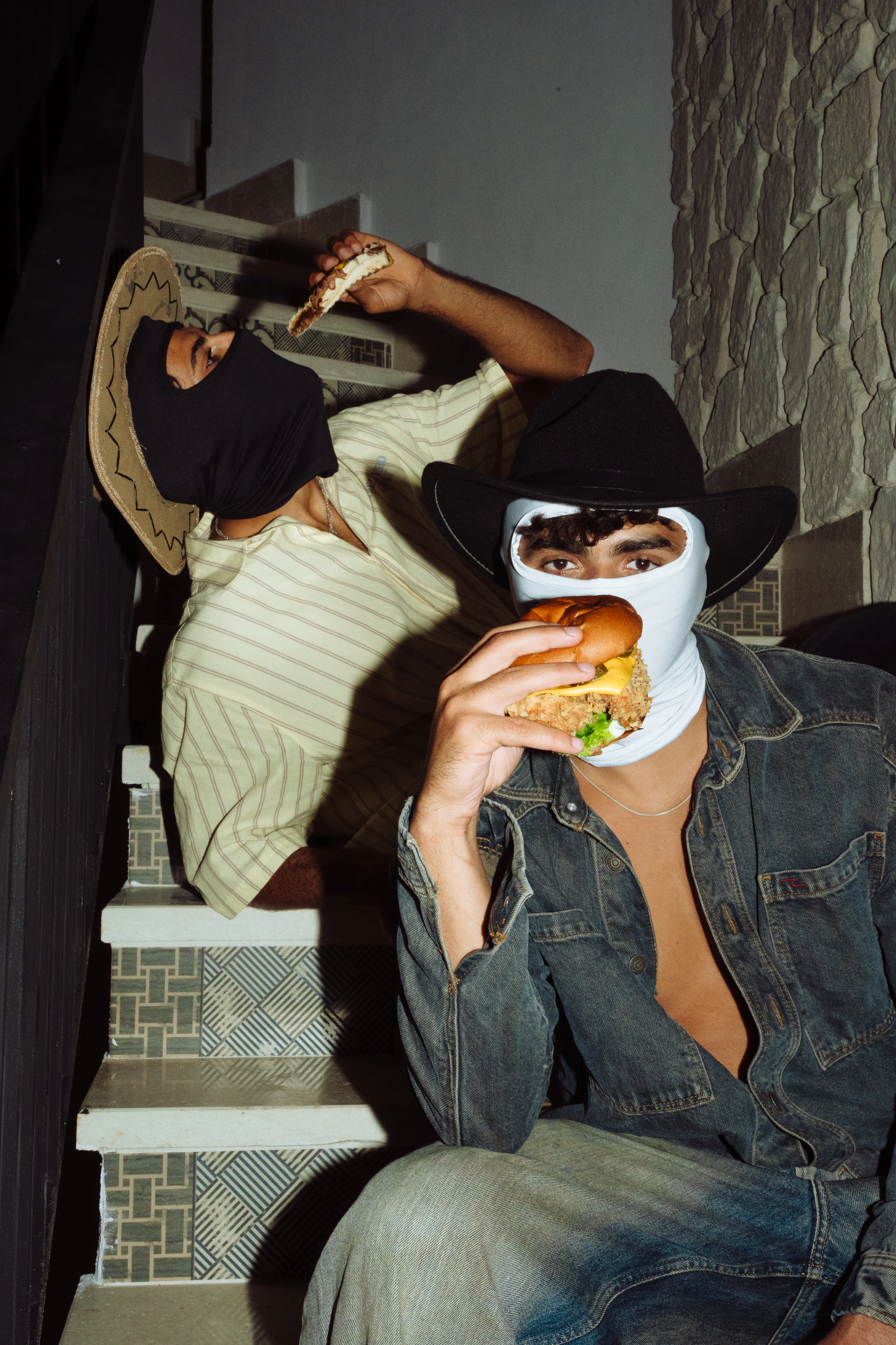 Pancho and Lefty masked as outlaws eating Little LongHorn burgers on a staircase